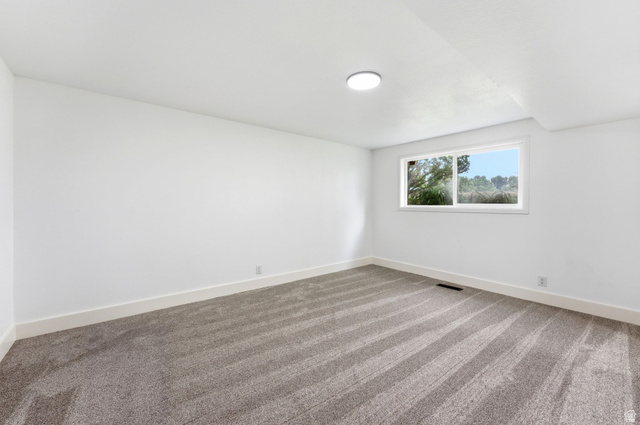 871 Bonita Way Centerville, UT 84014 - Photo 16 of 61 Bright interior space featuring a window, overhead lighting, crisp white walls, white baseboards, and a gray patterned carpet