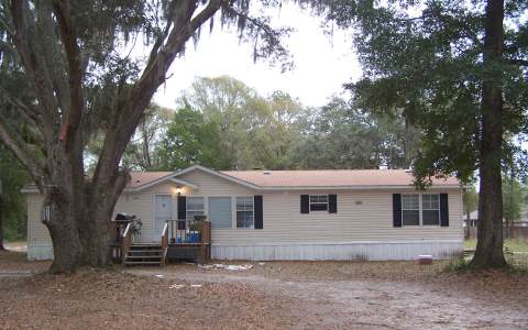 97350 Chester River Road Yulee, FL 32097 - Photo 1 of 1 a front view of a house with a garden and trees