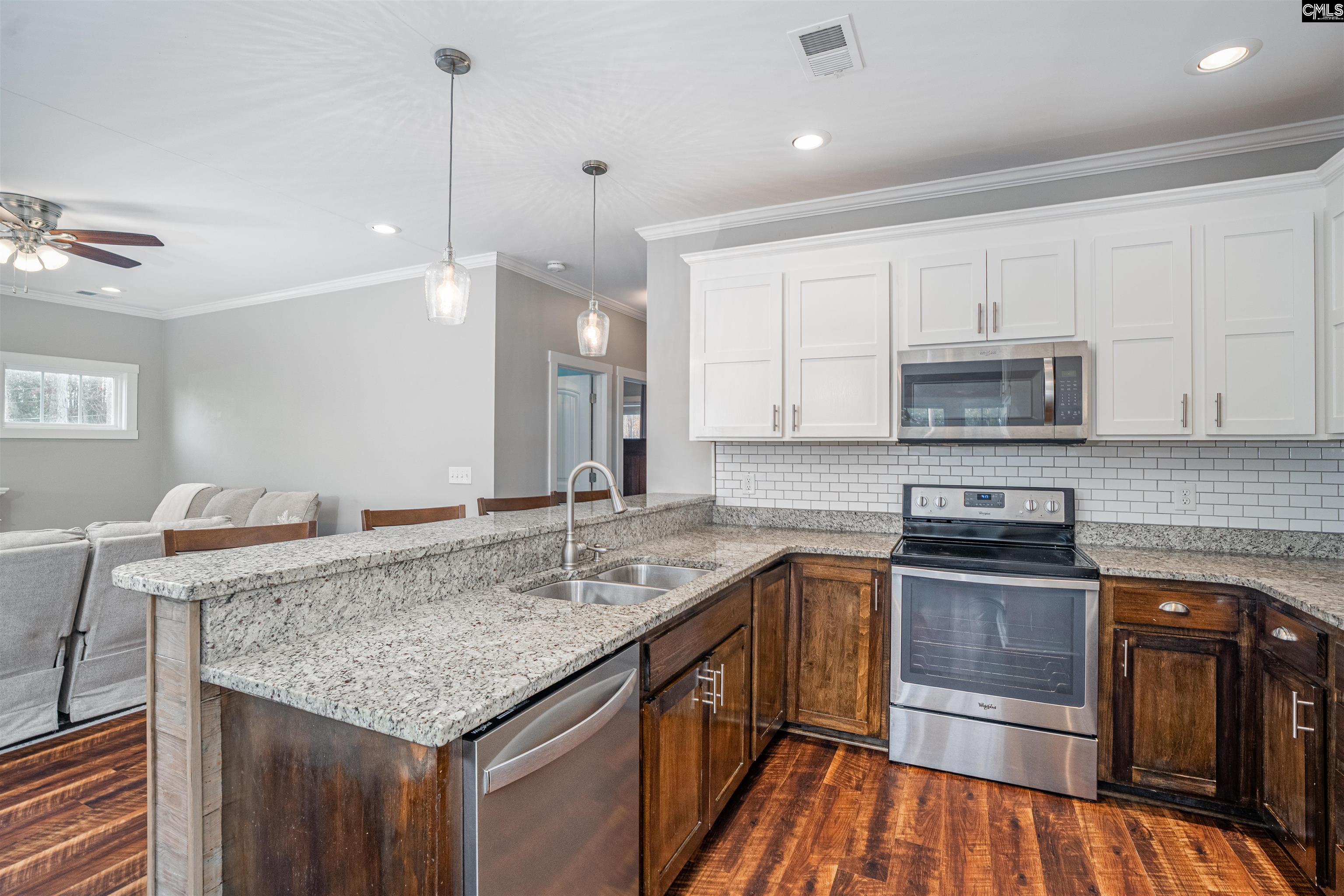 649 Sandbar Road Chapin, SC 29036 - Photo 11 of 40 a kitchen with granite countertop kitchen island stainless steel appliances a sink stove and cabinets