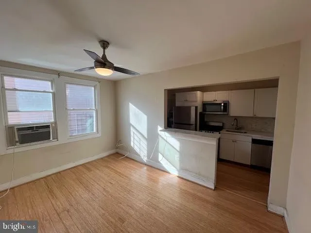 a kitchen with kitchen island granite countertop a sink cabinets and stainless steel appliances