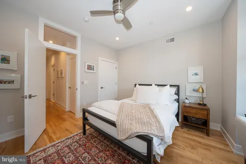 a bedroom with a bed and wooden floor