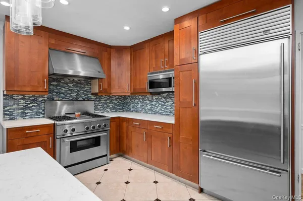 a kitchen with stainless steel appliances granite countertop a stove a sink and a refrigerator