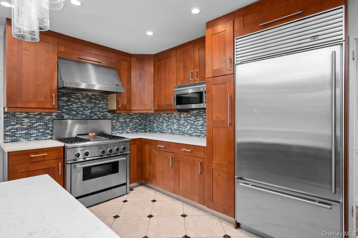 a kitchen with stainless steel appliances granite countertop a stove a sink and a refrigerator