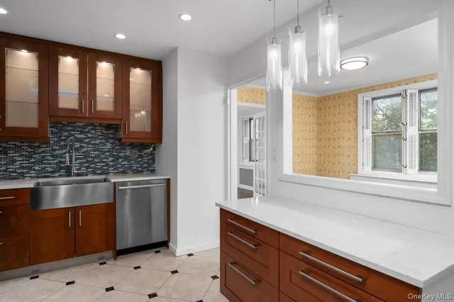 a kitchen with stainless steel appliances granite countertop a sink a stove and a window