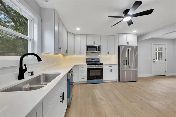 a kitchen with a sink stainless steel appliances and window