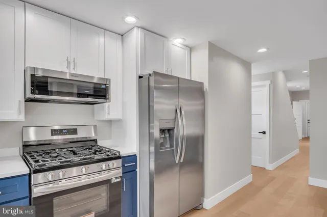 a kitchen with stainless steel appliances granite countertop a refrigerator and a stove