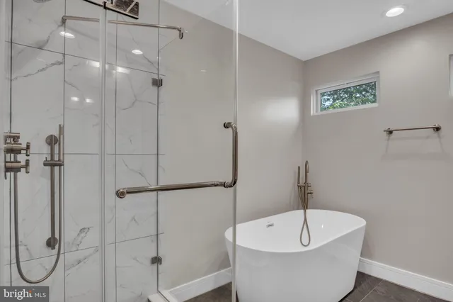 a white bath tub sitting next to a shower
