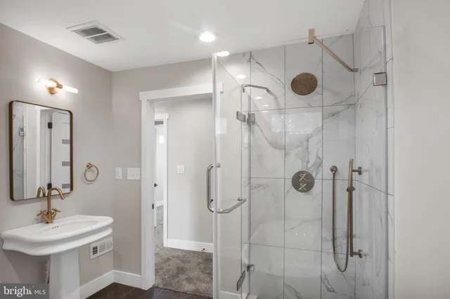 a bathroom with a sink mirror and shower