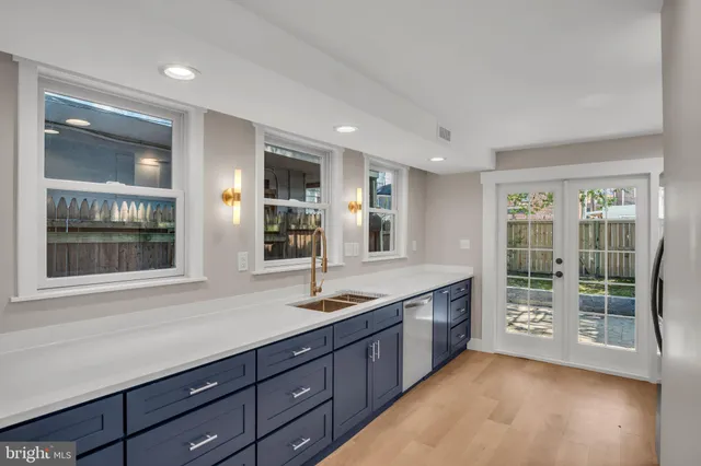 a large kitchen with granite countertop a large window and double vanity