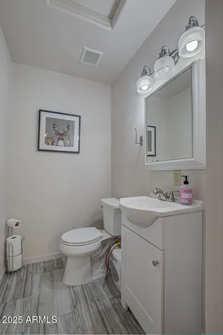 a bathroom with a toilet a sink and mirror