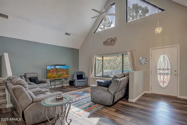 a living room with furniture a flat screen tv and a large window