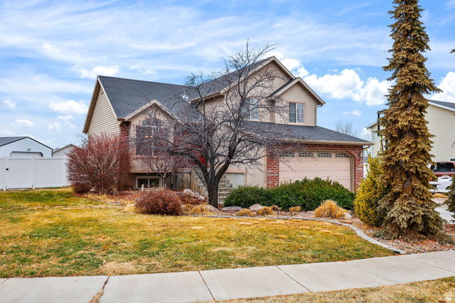 1263 780 West Clinton, UT 84015 - Photo 1 of 1 Traditional-style home with brick siding, a shingled roof, and an attached garage