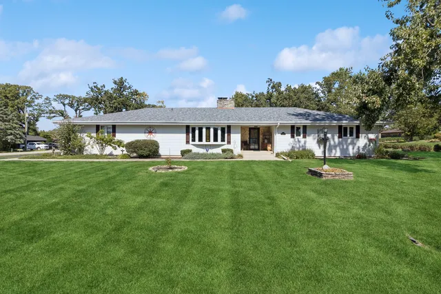 a front view of a house with a yard table and trees