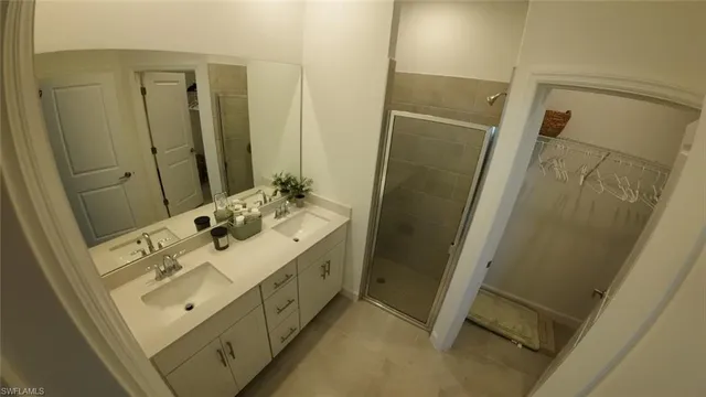 a bathroom with a sink mirror and shower