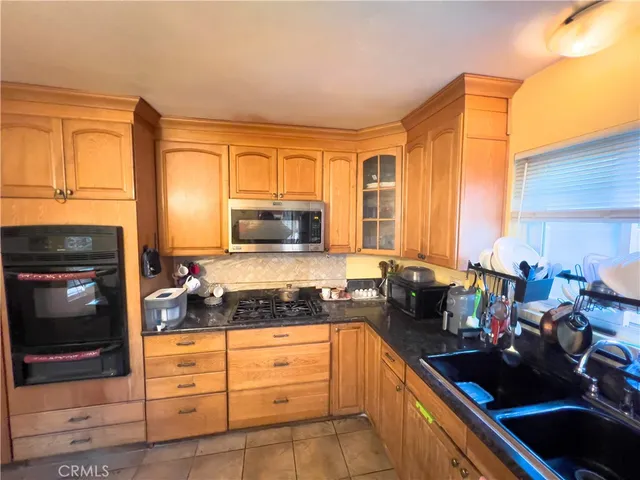 a kitchen with sink a stove and cabinets