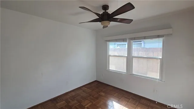 a view of a big room with wooden floor and windows