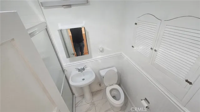 a bathroom with a toilet and a mirror