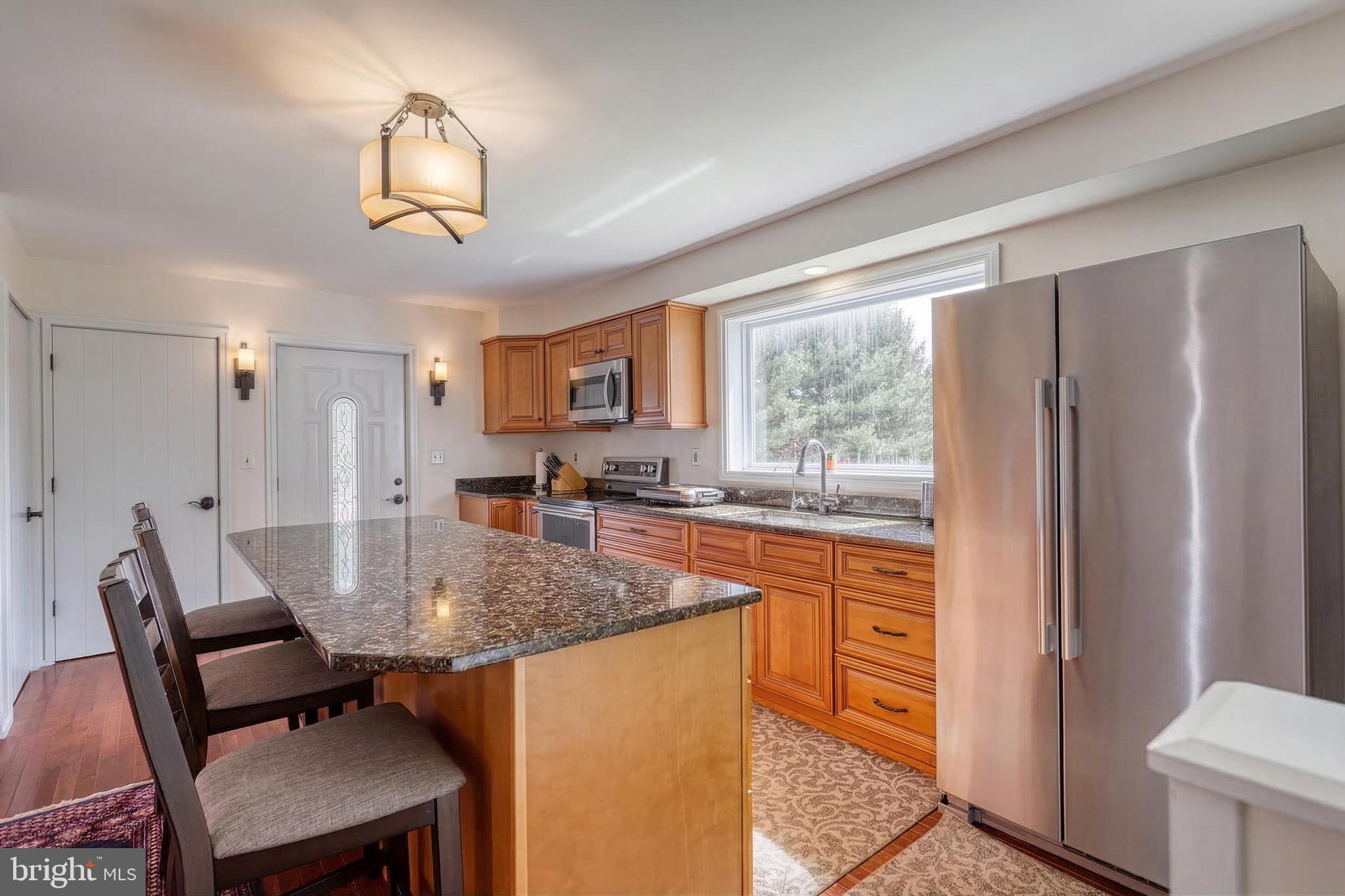 12534 Mt Olivet Road Felton, PA 17322 - Photo 16 of 75 a kitchen with stainless steel appliances granite countertop a table chairs and a refrigerator