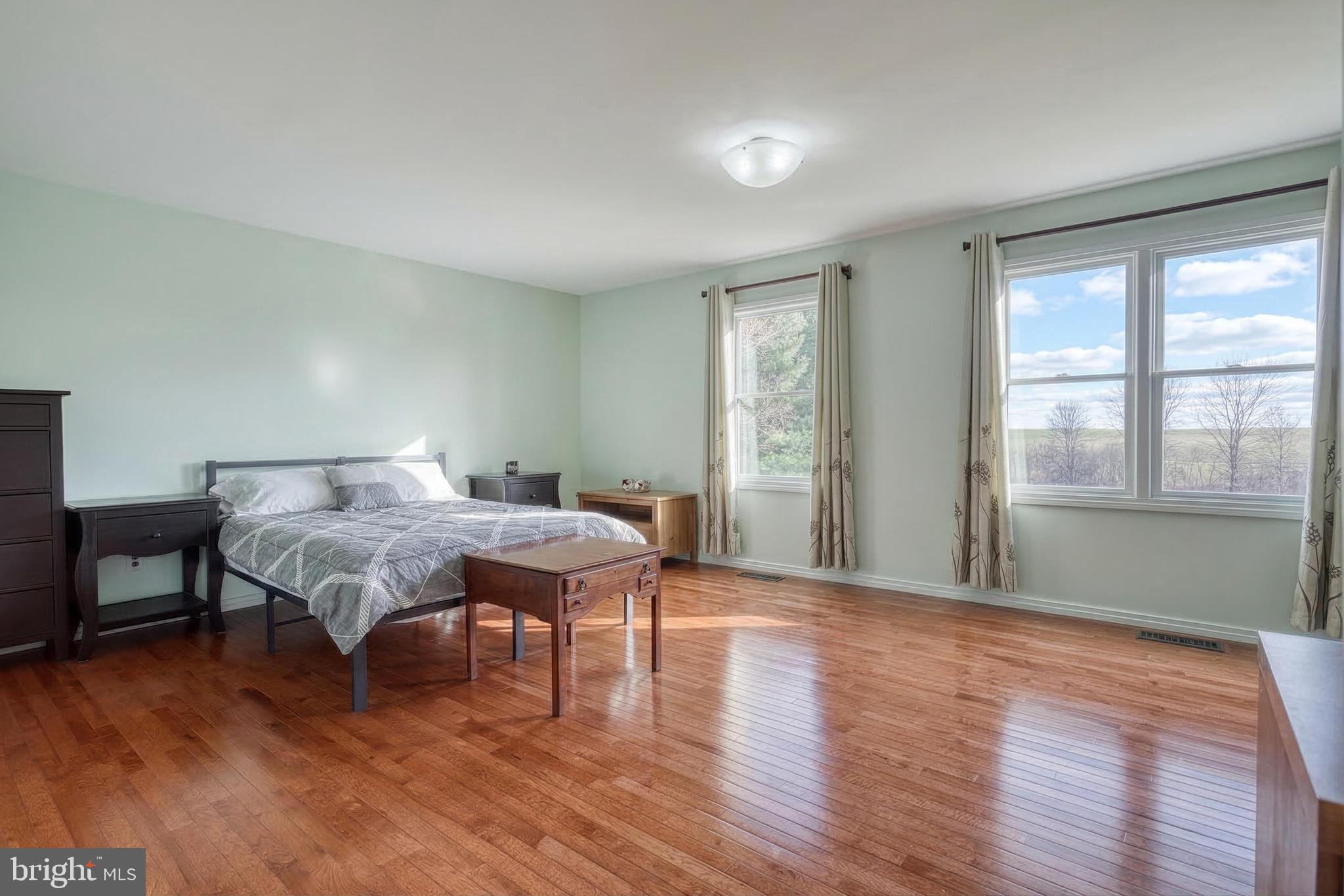 12534 Mt Olivet Road Felton, PA 17322 - Photo 31 of 75 a spacious bedroom with a bed and wooden floor