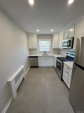 a large kitchen with cabinets and stainless steel appliances