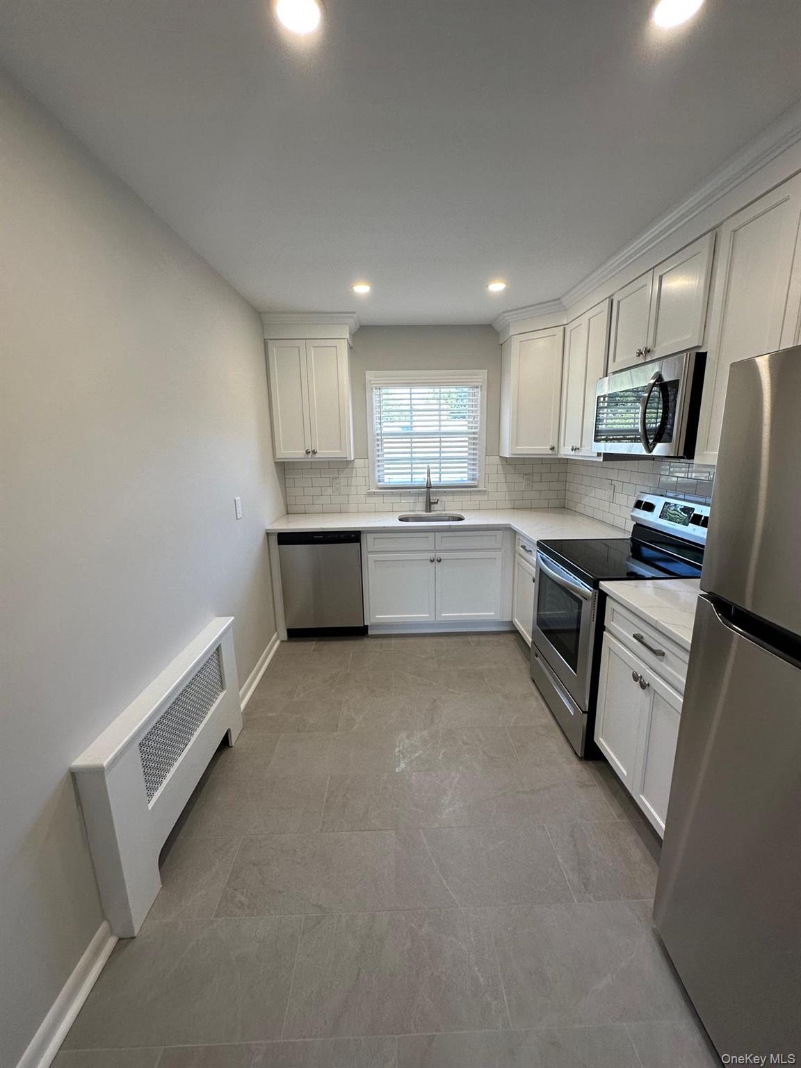 56 Carley Avenue, Unit 2 Huntington, NY 11743 - Photo 5 of 10 a large kitchen with cabinets and stainless steel appliances