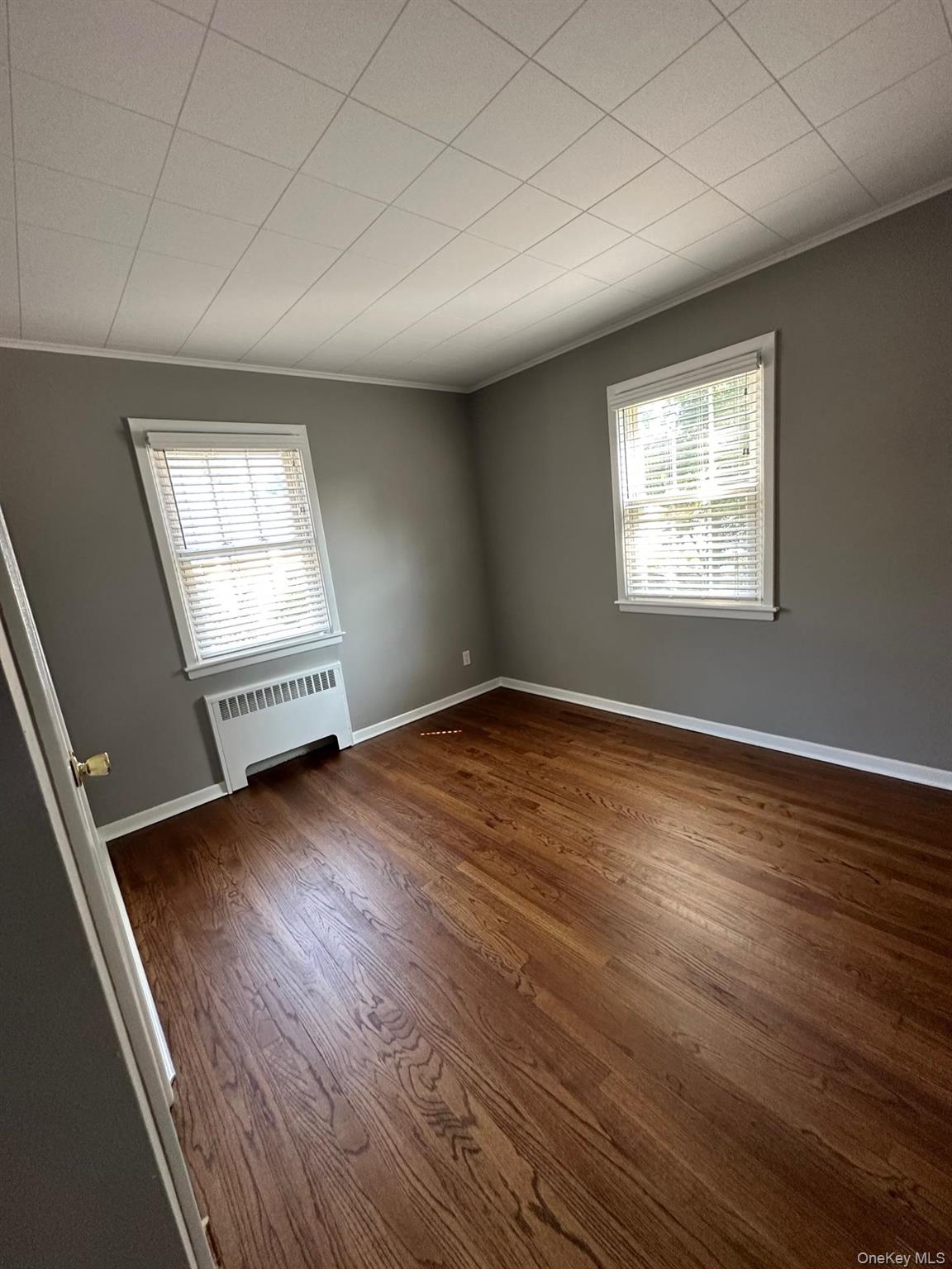 56 Carley Avenue, Unit 2 Huntington, NY 11743 - Photo 8 of 10 an empty room with wooden floor and windows