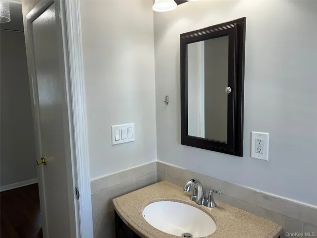 a bathroom with a granite countertop sink and a mirror