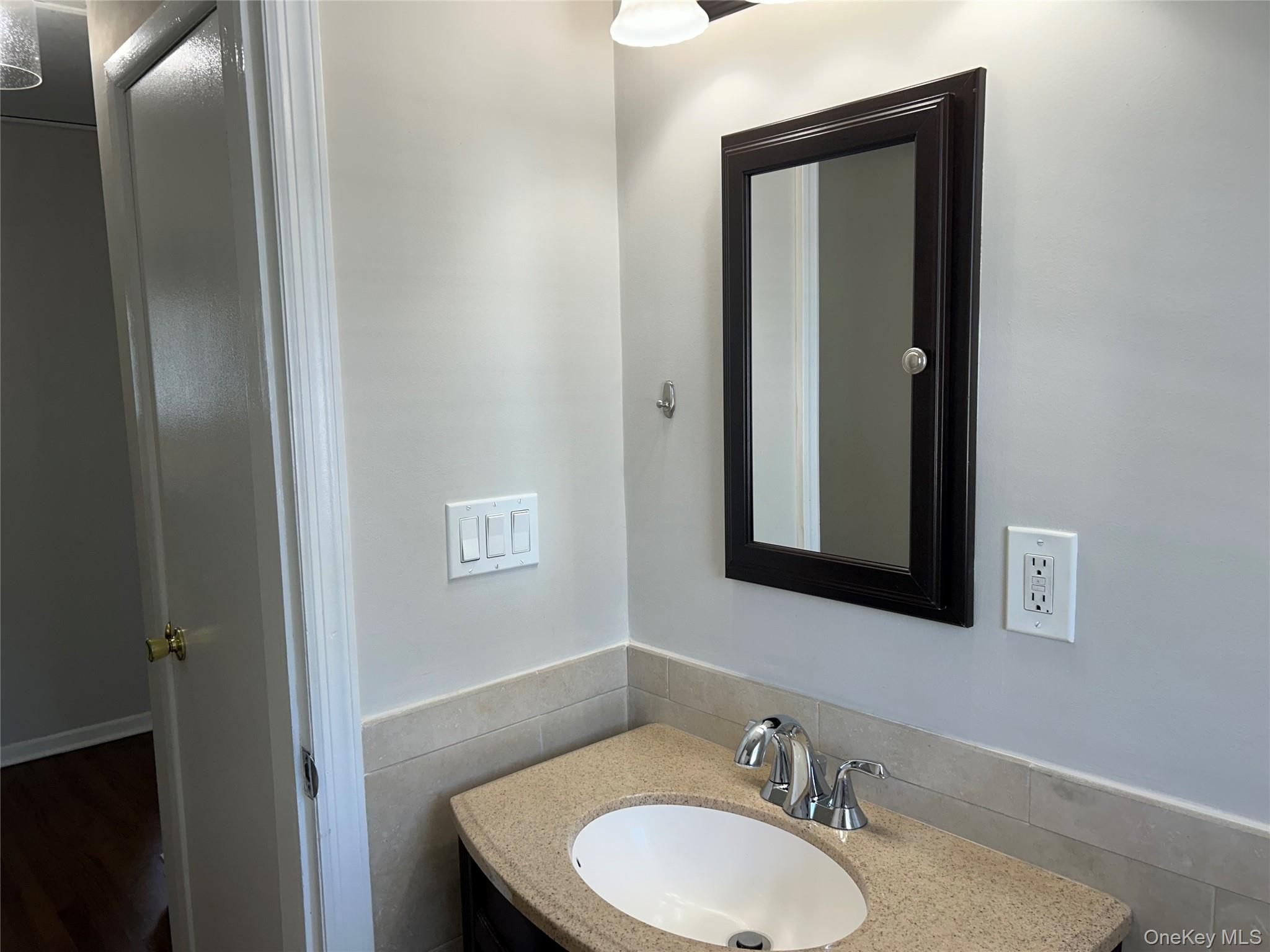 56 Carley Avenue, Unit 2 Huntington, NY 11743 - Photo 10 of 10 a bathroom with a granite countertop sink and a mirror