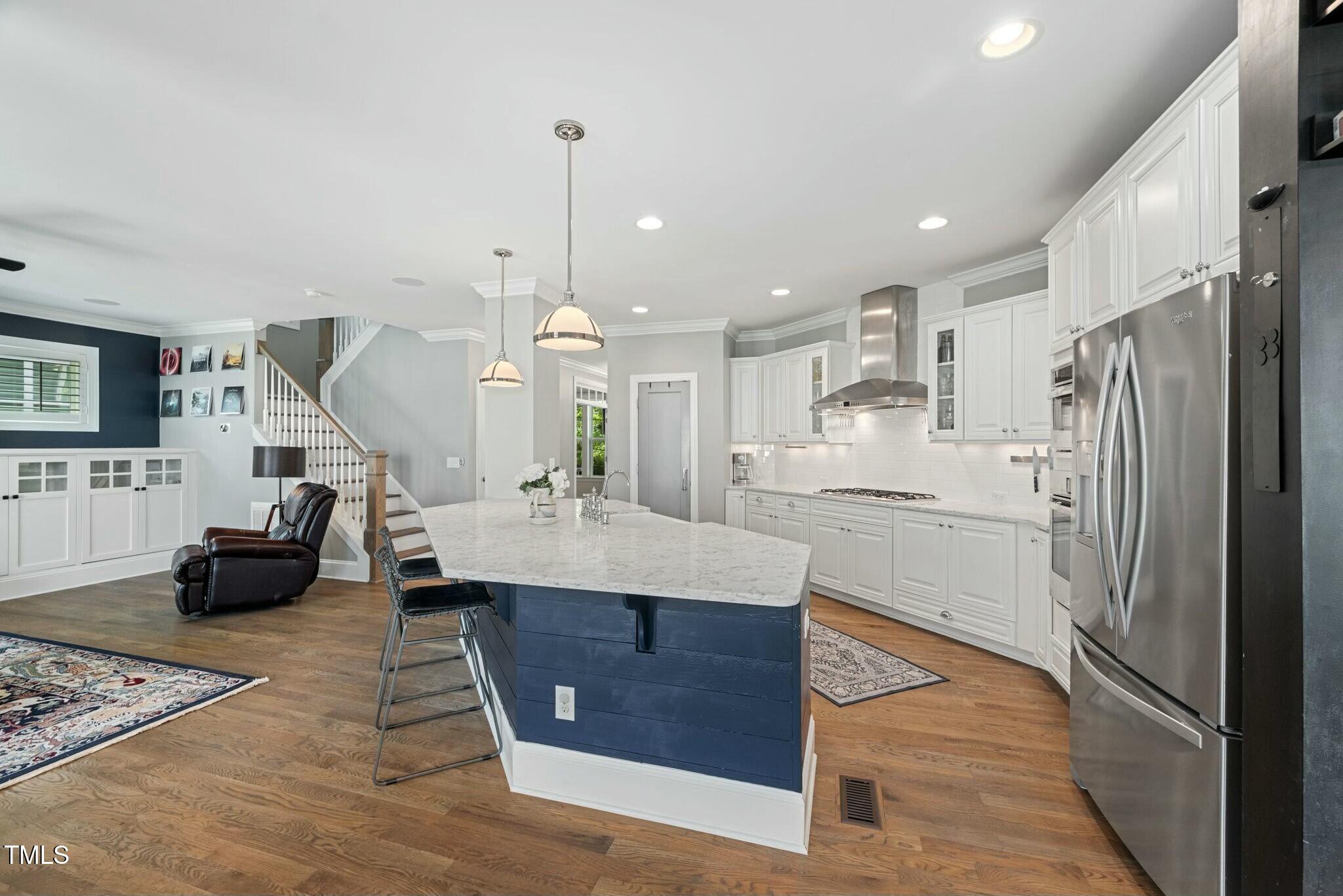 11808 Venture Oak Way Raleigh, NC 27613 - Photo 11 of 42 a kitchen with stainless steel appliances kitchen island granite countertop a refrigerator a sink dishwasher and a stove with wooden floor