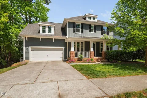 a front view of a house with a yard and trees
