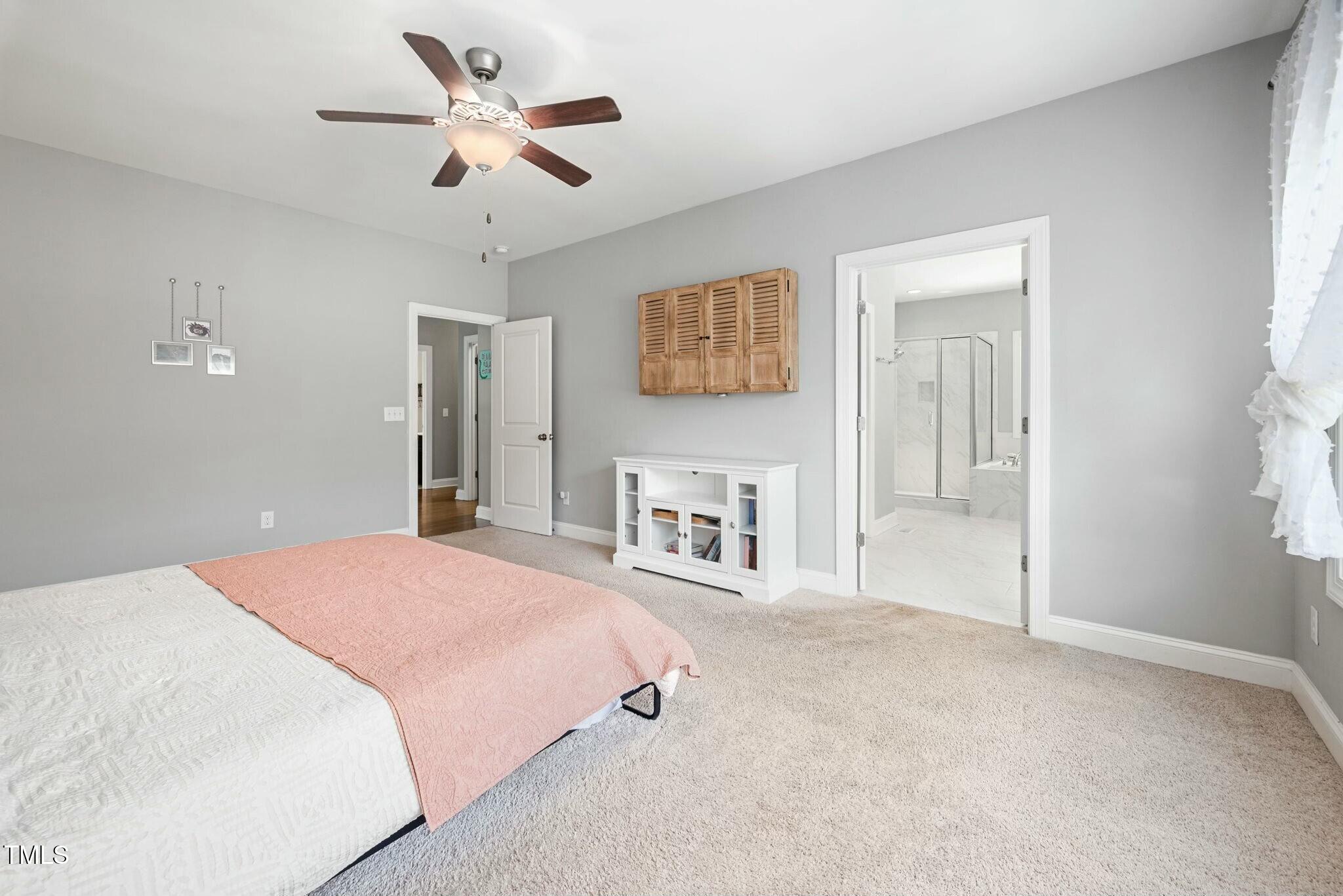 11808 Venture Oak Way Raleigh, NC 27613 - Photo 23 of 42 a spacious bedroom with a bed and a ceiling fan