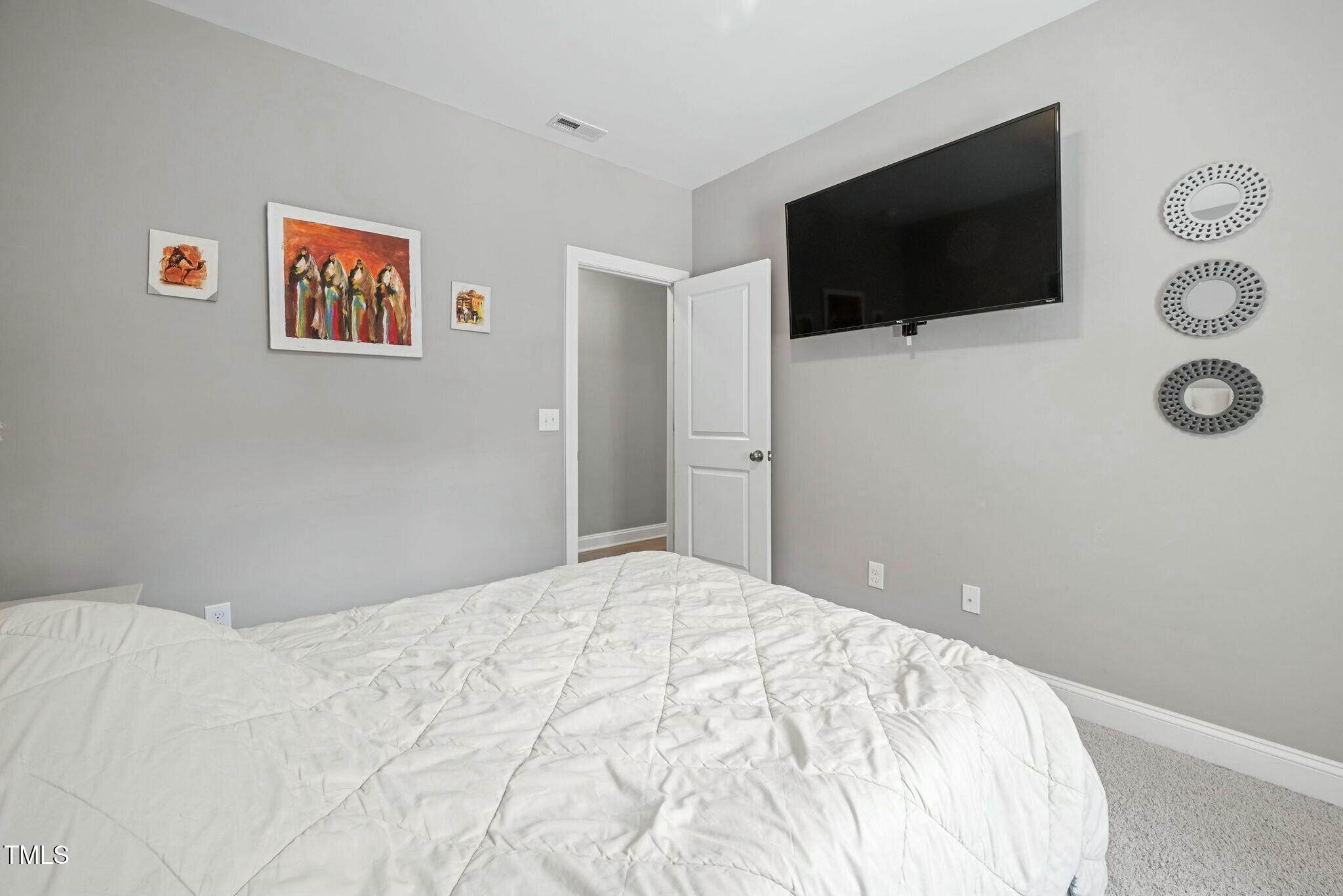 11808 Venture Oak Way Raleigh, NC 27613 - Photo 33 of 42 a bedroom with a bed and a flat screen tv