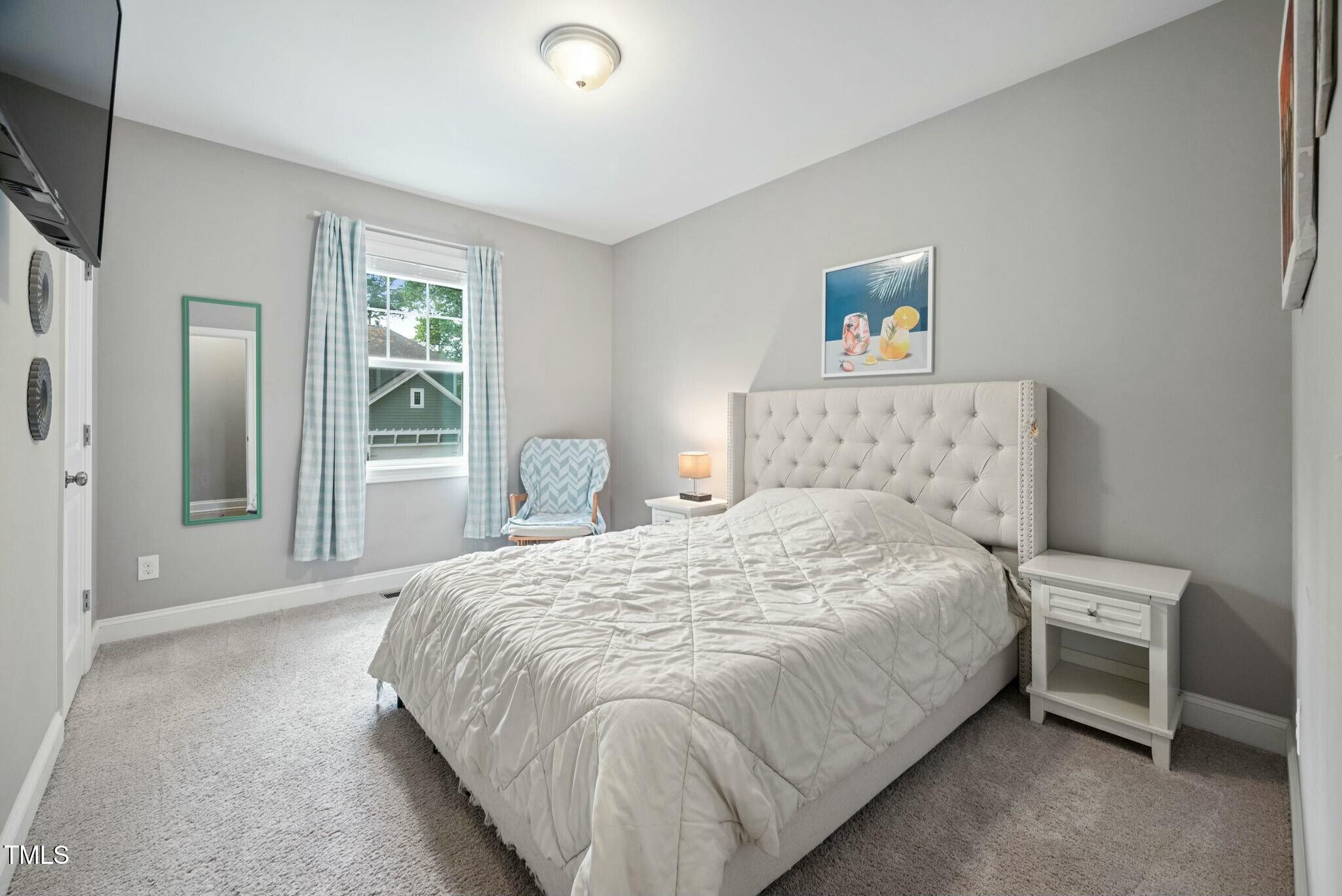 11808 Venture Oak Way Raleigh, NC 27613 - Photo 34 of 42 a bedroom with a bed and a large window