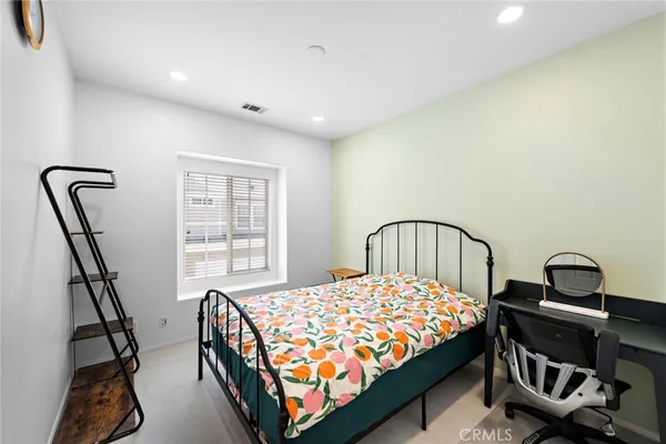 a bedroom with a bed next to a window