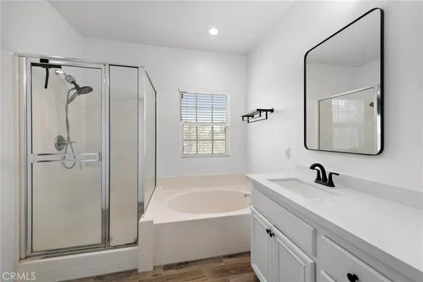 a bathroom with a tub sink and mirror