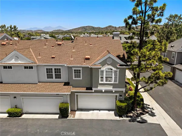 a front view of a house with a garden and mountain view