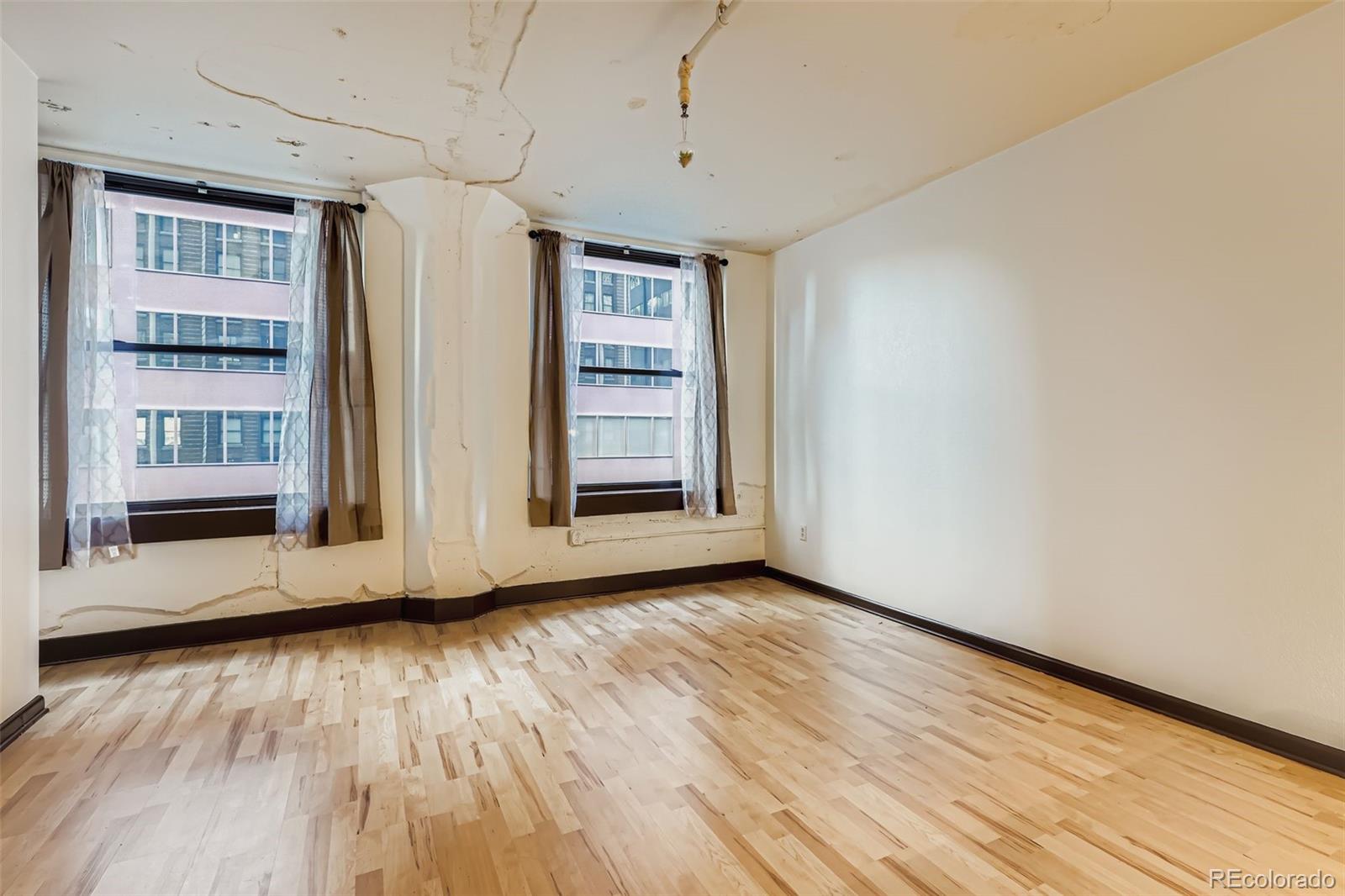 444 17th Street, Unit 404 Denver, CO 80202 - Photo 18 of 37 a view of an empty room with wooden floor and a window