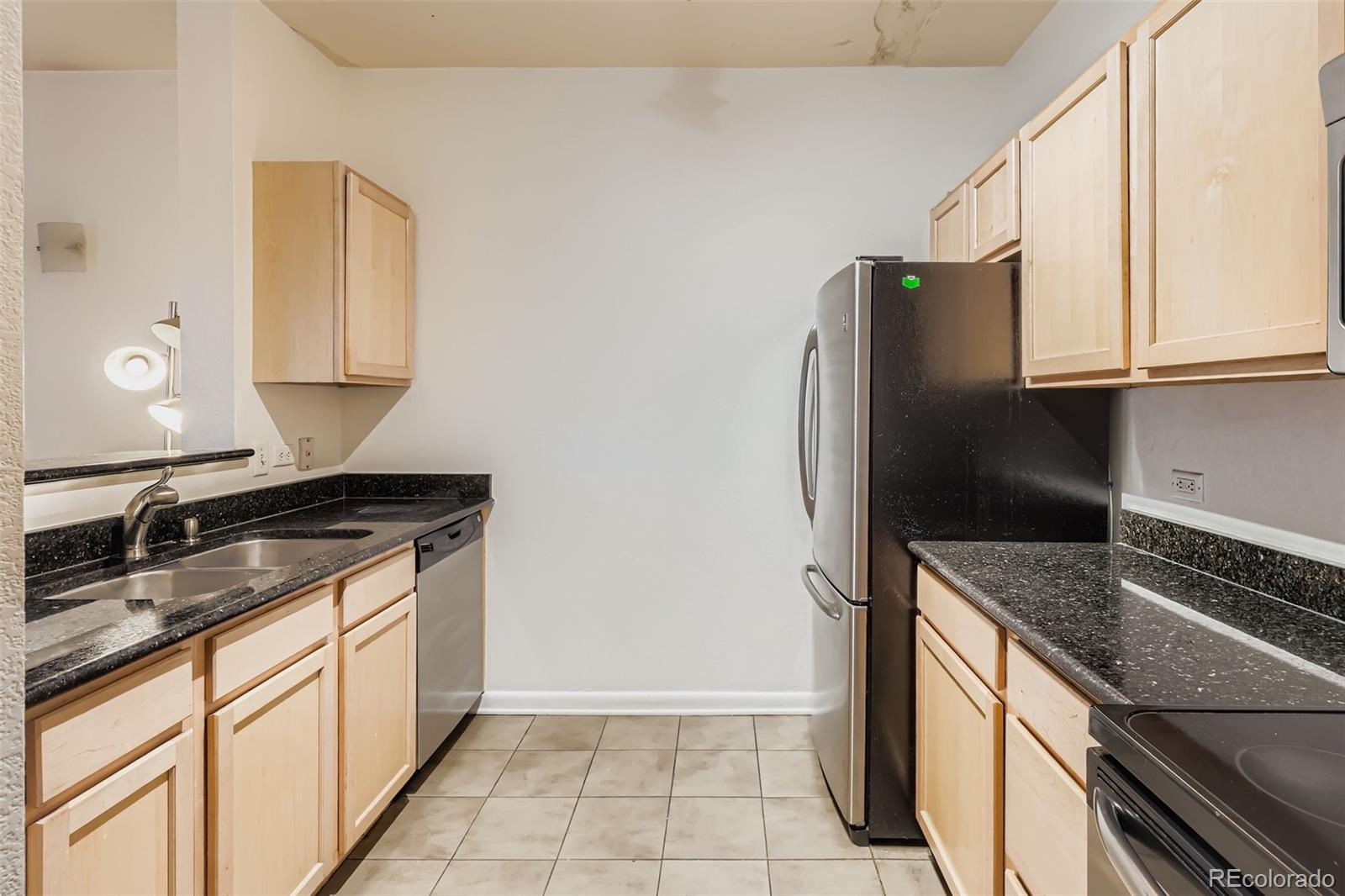 444 17th Street, Unit 404 Denver, CO 80202 - Photo 4 of 37 a kitchen with granite countertop a refrigerator and a sink
