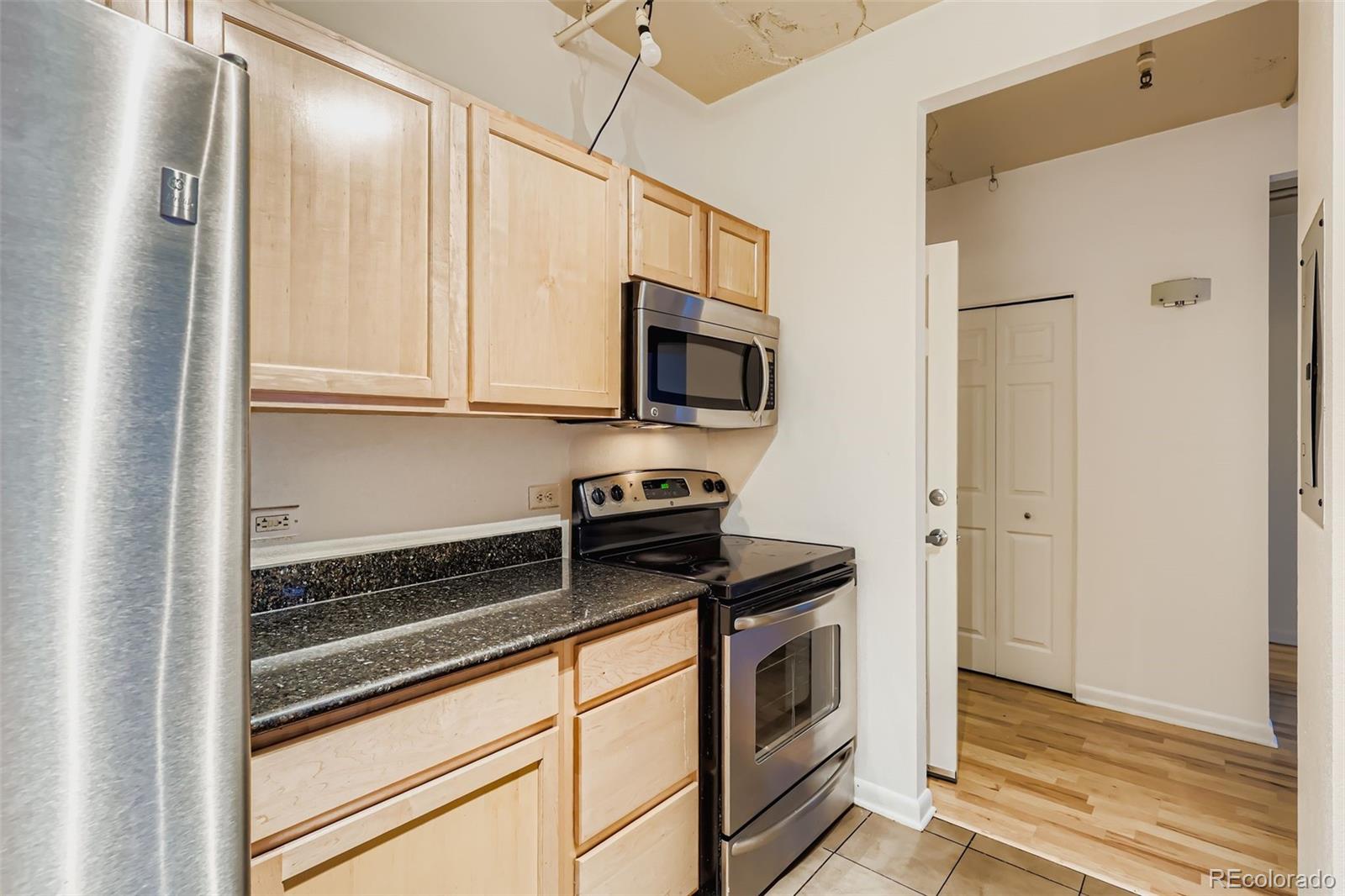 444 17th Street, Unit 404 Denver, CO 80202 - Photo 5 of 37 a kitchen with stainless steel appliances white cabinets and a stove top oven