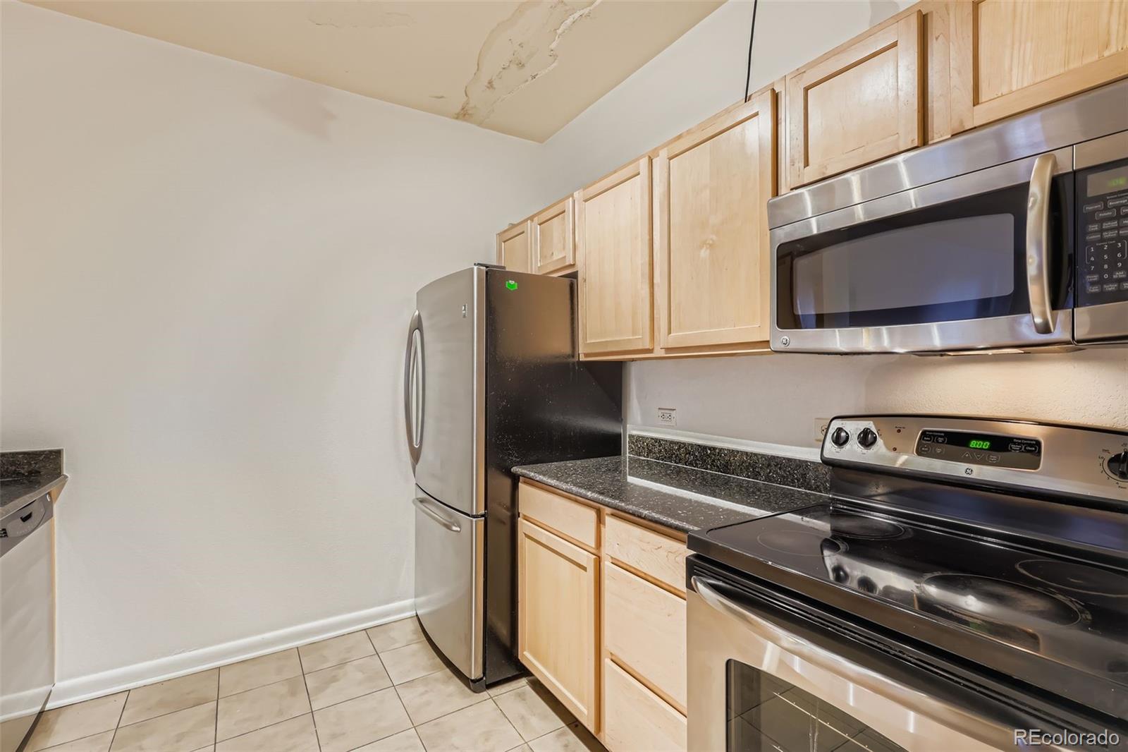 444 17th Street, Unit 404 Denver, CO 80202 - Photo 6 of 37 a kitchen with stainless steel appliances and granite countertop white cabinets