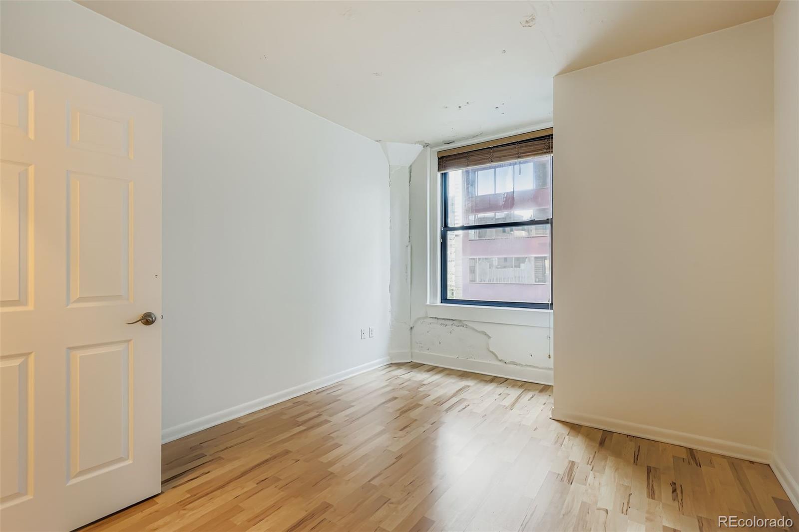 444 17th Street, Unit 404 Denver, CO 80202 - Photo 10 of 37 a view of an empty room with wooden floor and a window