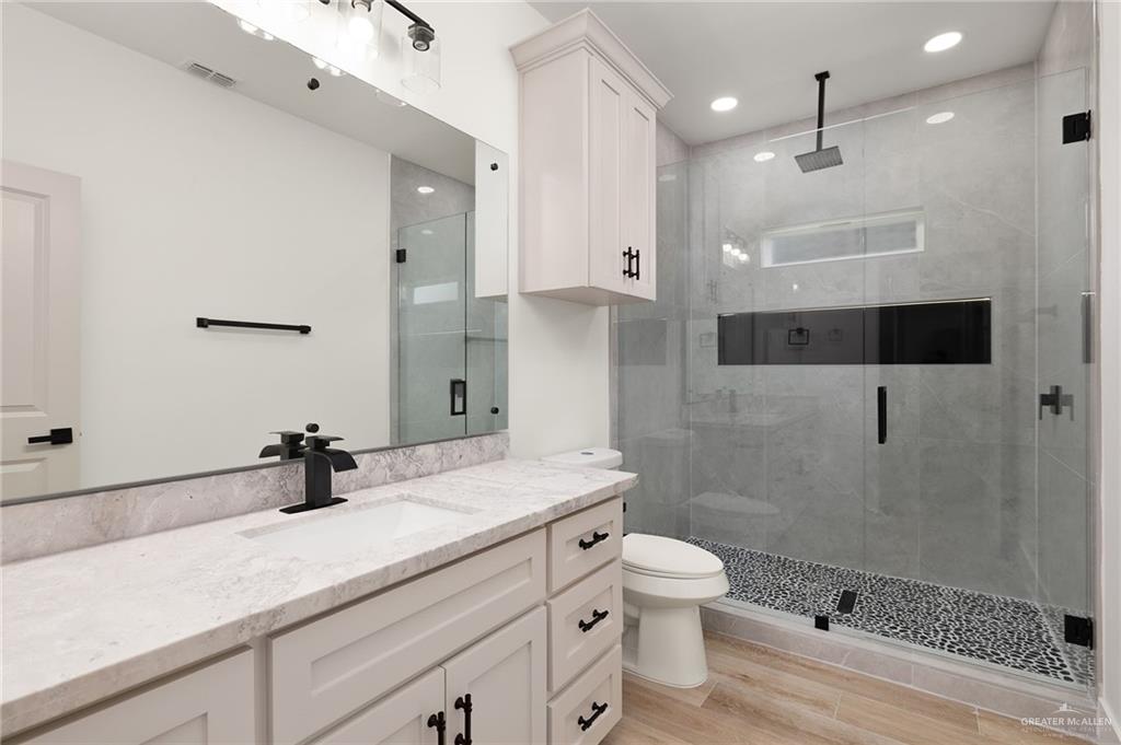 2525 Trinity Avenue McAllen, TX 78504 - Photo 21 of 33 a bathroom with a sink a toilet a mirror and shower