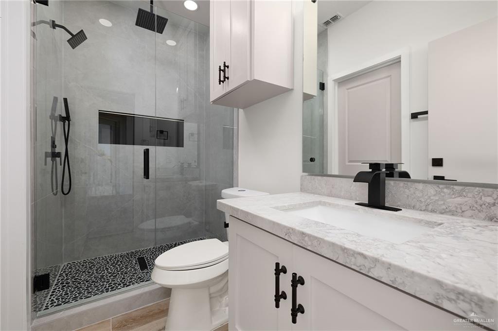 2525 Trinity Avenue McAllen, TX 78504 - Photo 22 of 33 a bathroom with a granite countertop sink a toilet and shower