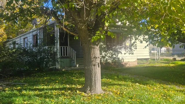 a backyard of a house with lots of green space and fountain in the back