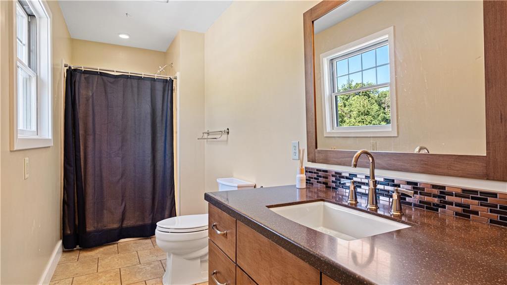695 North Ben Franklin Road Indiana, PA 15701 - Photo 13 of 25 a bathroom with a granite countertop sink a toilet a mirror and shower