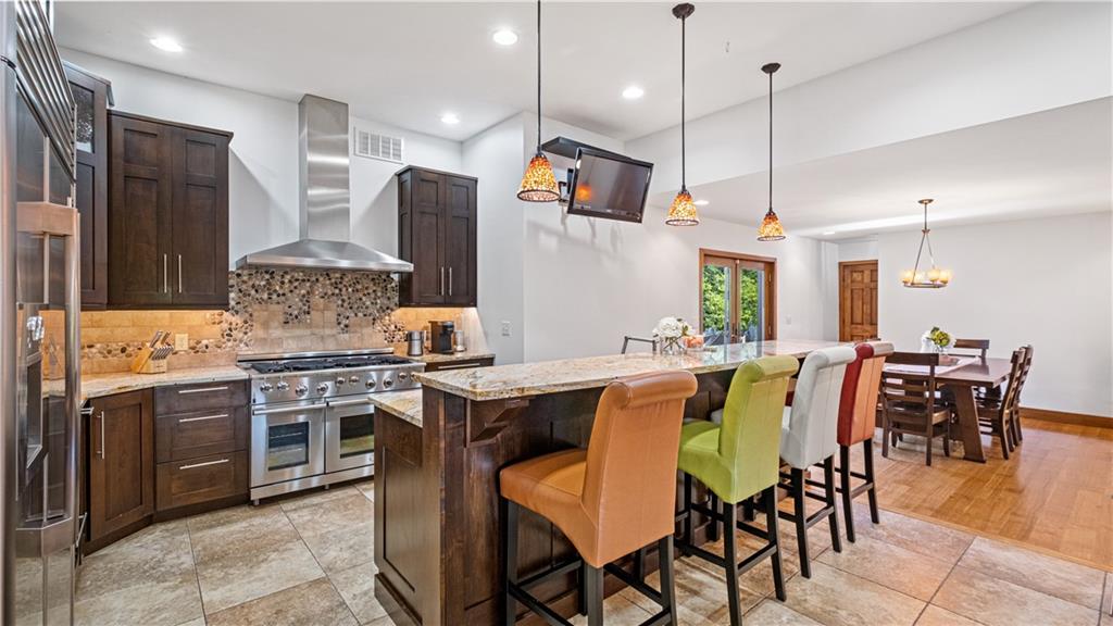695 North Ben Franklin Road Indiana, PA 15701 - Photo 8 of 25 a kitchen with stainless steel appliances granite countertop a stove a sink a dining table and chairs with wooden floor