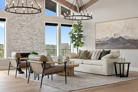 a living room with furniture a chandelier and a table