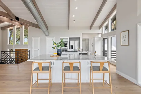 a kitchen with stainless steel appliances kitchen island granite countertop a dining table chairs and granite counter tops