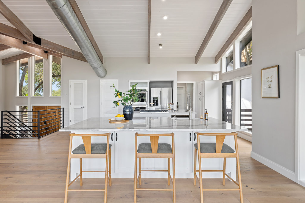 6905 Ladera Norte Austin, TX 78731 - Photo 17 of 40 a kitchen with stainless steel appliances kitchen island granite countertop a dining table chairs and granite counter tops