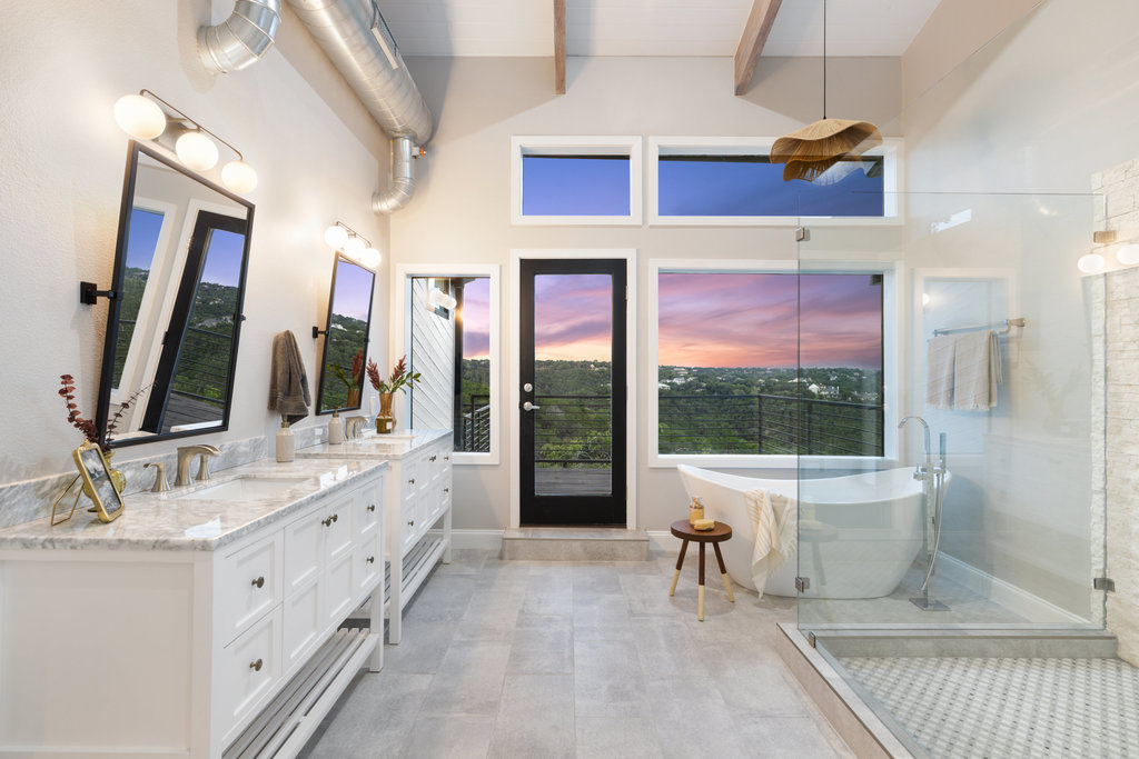 6905 Ladera Norte Austin, TX 78731 - Photo 7 of 40 a bathroom with a double vanity sink a large mirror and a bathtub